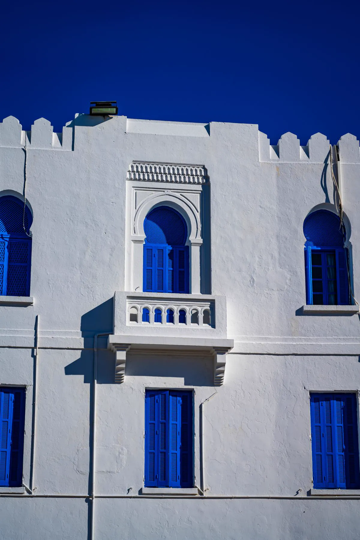 Façade blanche aux fenêtres et volets bleus de Sidi Bou Saïd
