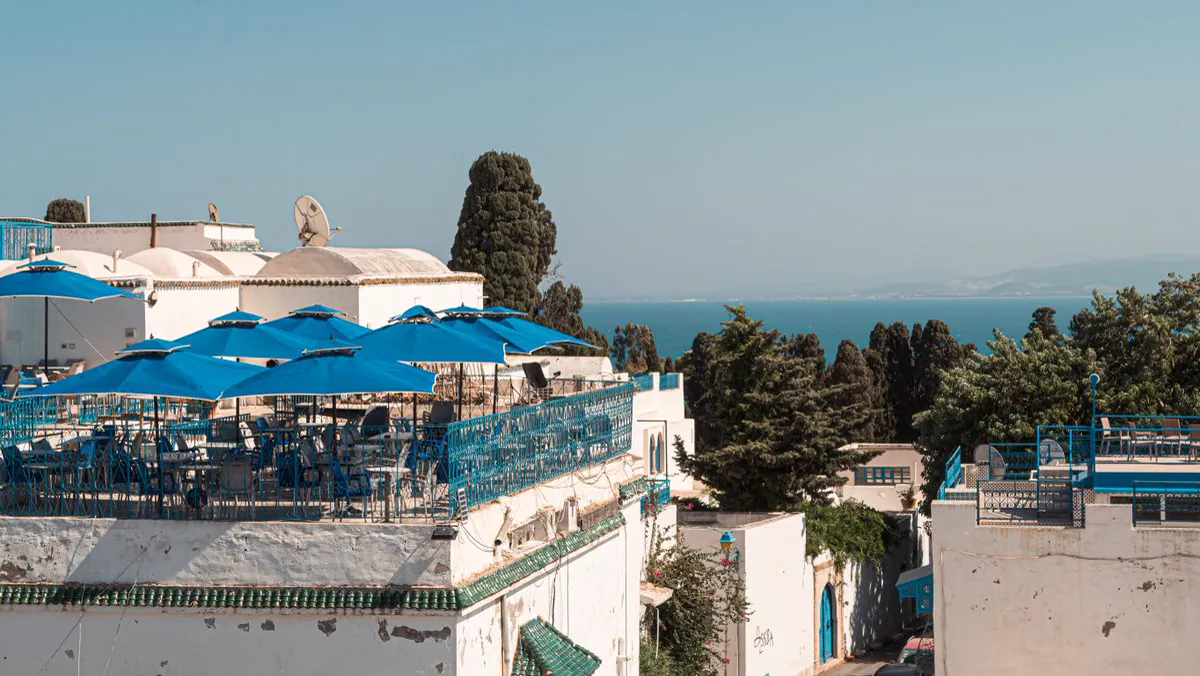 Terrasse aux parasols bleus surplombant la mer à Sidi Bou Saïd